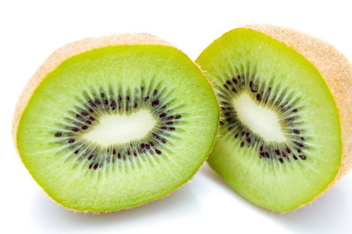 カットしたキウイフルーツの断面、黄緑色の果肉と黒い種