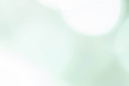 波打つ素材のぼかしを活かした柔らかい淡い緑の光の抽象写真