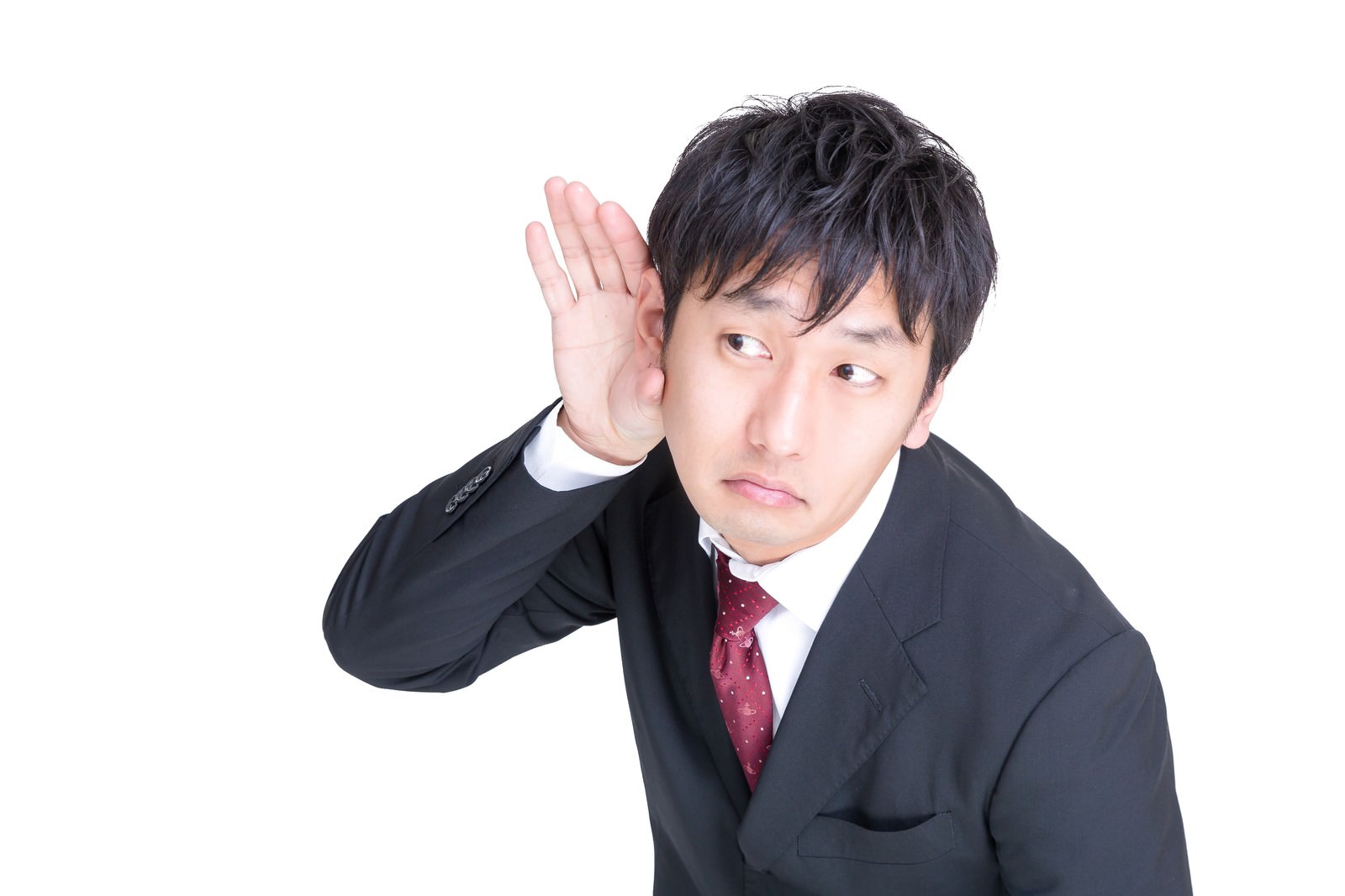 記者の質問に耳を澄ますスーツ姿の男性［モデル：大川竜弥］