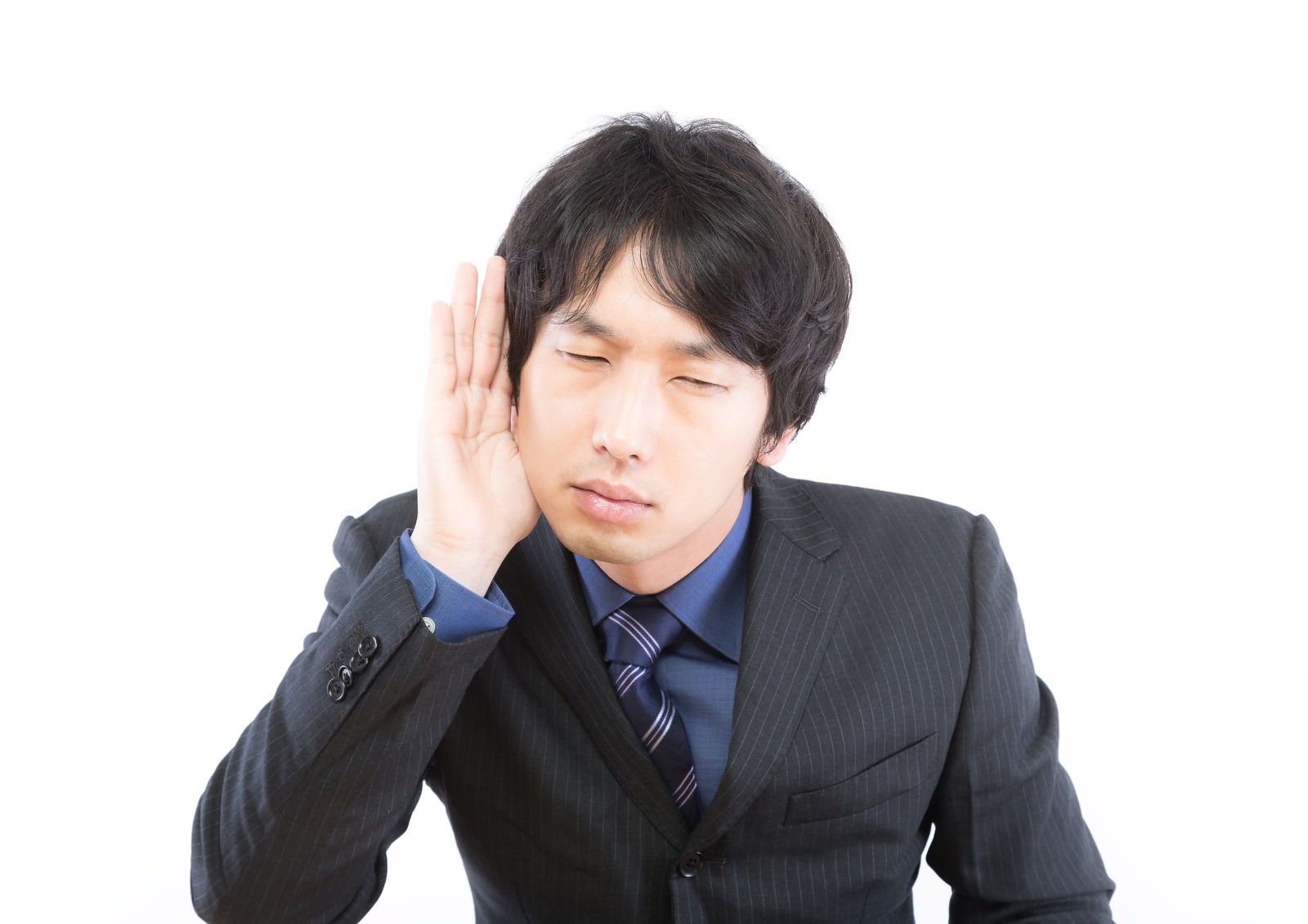 耳に手を当てて聞き耳を立てる男性［モデル：大川竜弥］