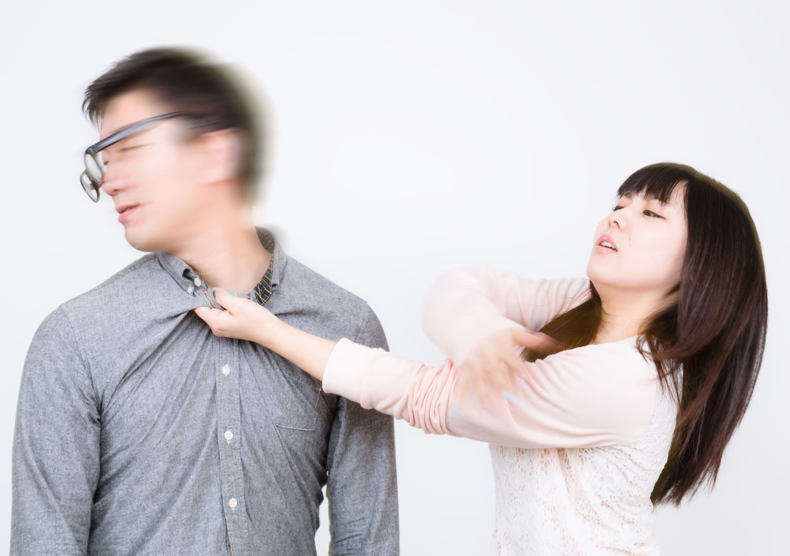 男性の肩に手を置いてビンタ寸前の表情の彼女［モデル：OZPA Lala］