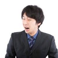 口を開けて左を向く黒い縦じまスーツの号泣する男性の写真