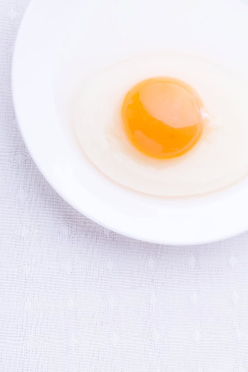 白いお皿の上に割った生たまご