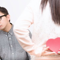 ハート型の紙を持つ女性と彼女ができる5秒前の男性の写真