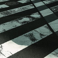 白線が交差するすり減った横断歩道の写真