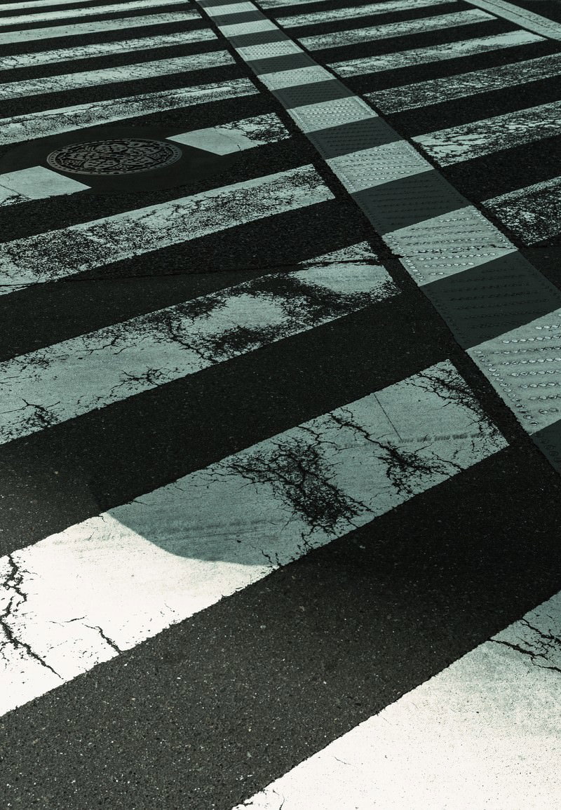 黒と白の縞模様が見える摩耗した横断歩道の路面