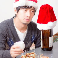 たこ焼きと酒瓶で一人クリスマスの男性の写真