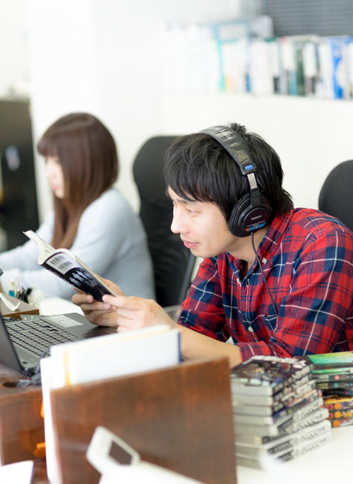 職場で漫画を読みながら仕事をするエンジニア男性