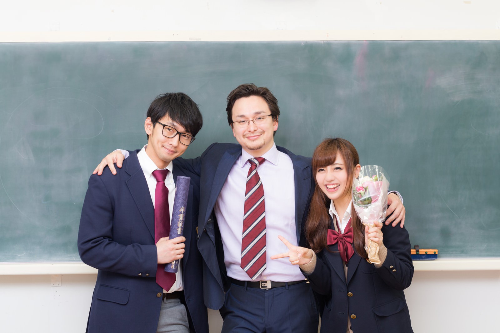 教室の黒板前で卒業生と一緒に記念撮影する担任教師［モデル：Max_Ezaki 大川竜弥 河村友歌］