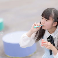 シャボン玉を吹くツインテールの女の子の写真