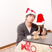 こたつでビール片手に一人クリスマスの男性の写真