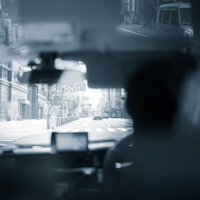 タクシー車内のダッシュボードとルームミラー越しに見える街並みの写真