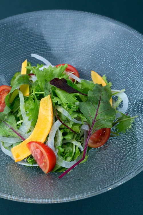 灰色の皿に盛られた色合い豊かなサラダ