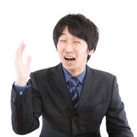 泣きながら右手を挙げる男性の写真