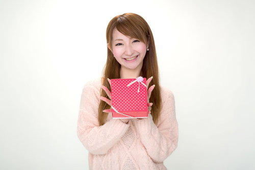 ピンクの水玉箱を笑顔で渡すバレンタインの女性