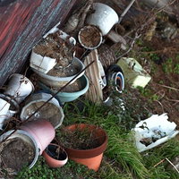 割れた庭先の花瓶と荒れた廃墟の写真