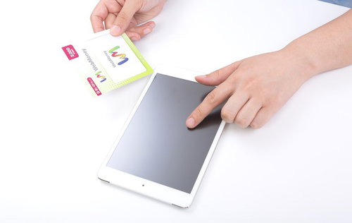 タブレット端末に保護シートを貼ろうとする2人の手元