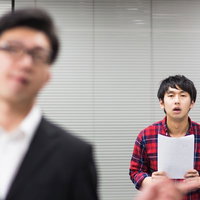 白い紙を持って唖然とするチェック柄シャツのデザイナーの写真