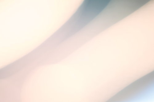斜めの帯状の影が横切る明るい柔らかい光のぼけた抽象写真