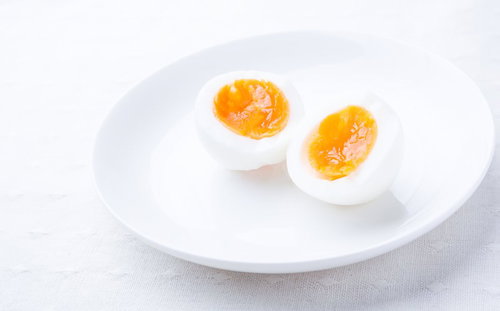 熱湯で8分間茹でた半熟たまご（縦割り）白い皿盛り
