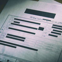 個人情報を黒塗りにした不気味な怪文書と机上の編集済み書類の写真