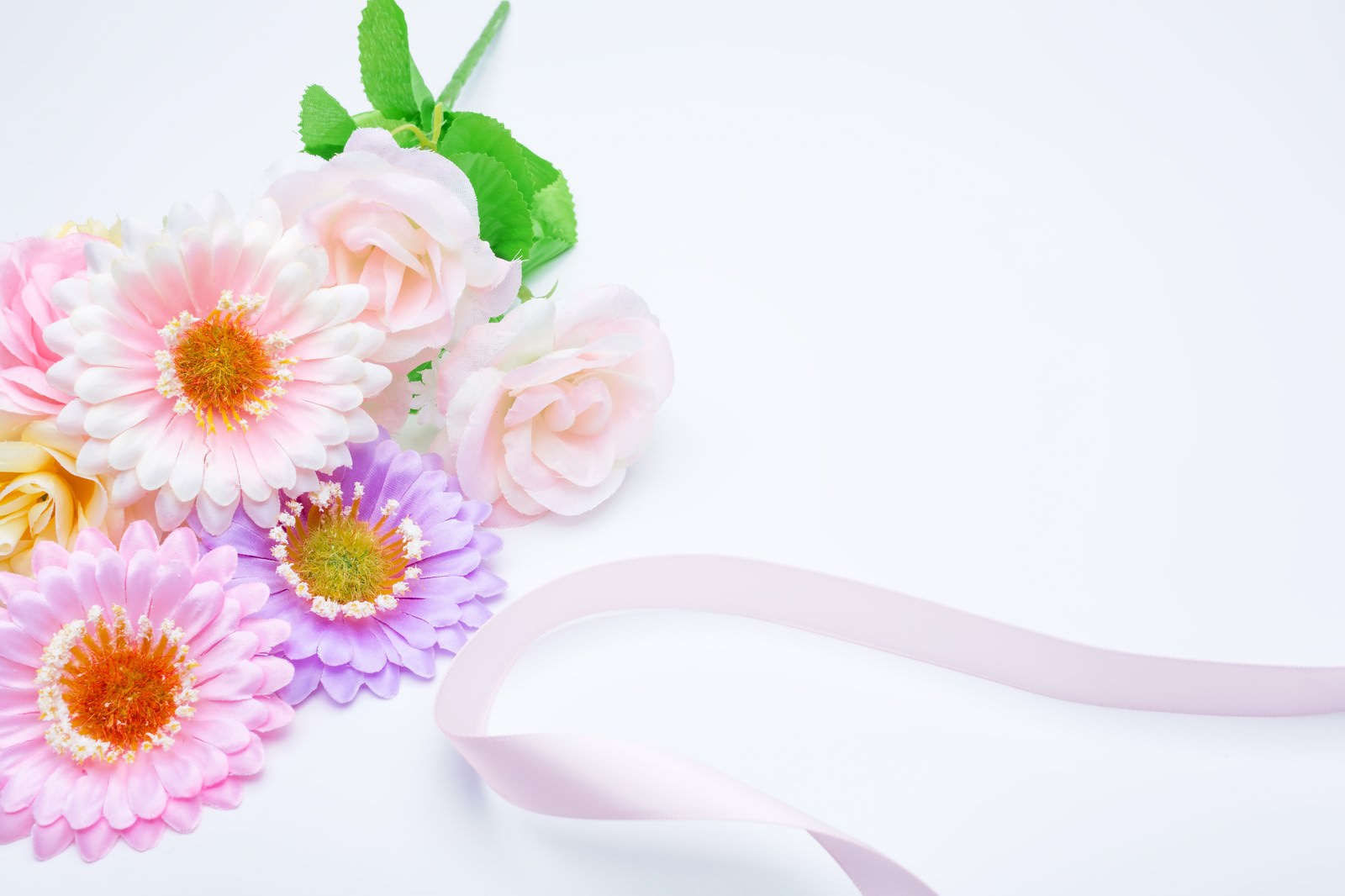 ピンクと紫のガーベラ、薄ピンクのバラとリボンが付いた花束