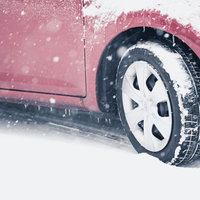 スリップ注意！雪道を走行する車の写真