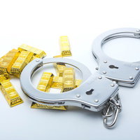 金の延べ棒に巻かれた手錠の写真