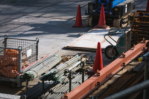 三角コーンと建設機械が並ぶ工事現場の資材置き場