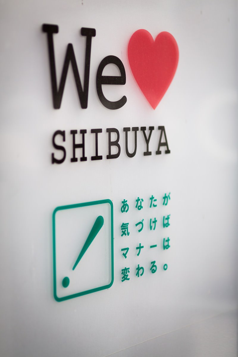渋谷の分煙喫煙所の看板。赤いハートと黒い文字で「We LOVE SHIBUYA」と表記