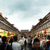 カラフルな提灯や看板の下を歩く大勢の人で賑わう浅草仲見世の写真