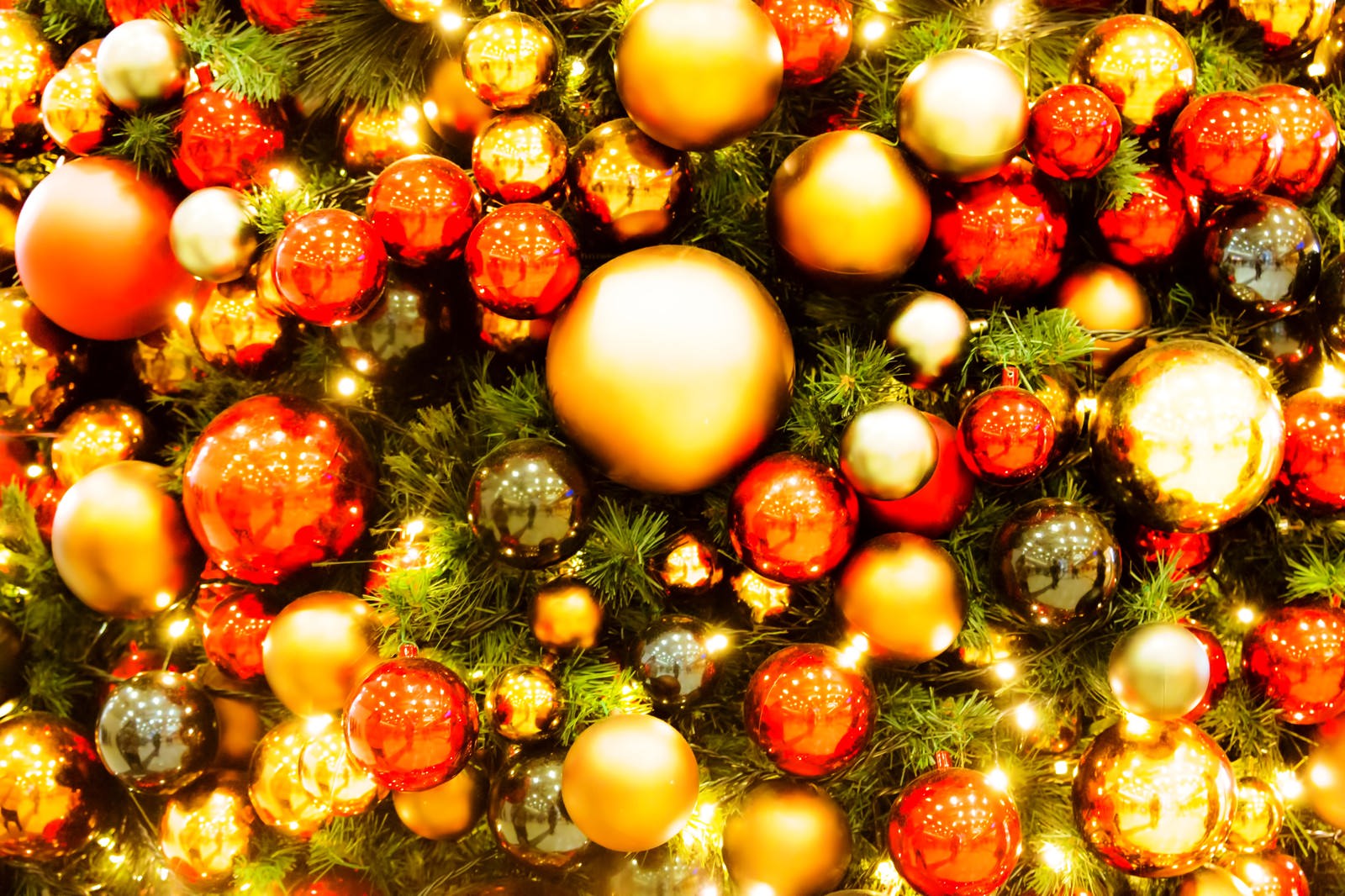 クリスマスツリーに飾られたゴールドと赤のオーナメント、電球