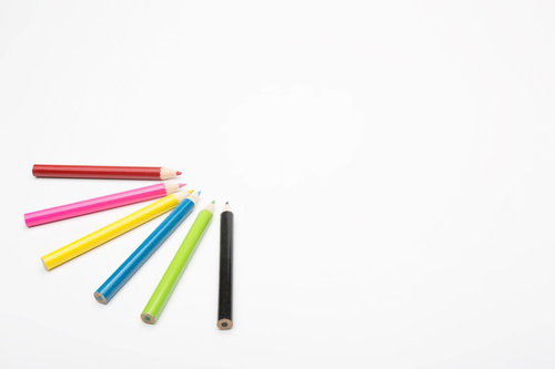 6色の色鉛筆が扇状に並んだ白背景