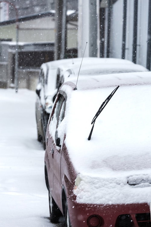 雪が積もった駐車場の車とワイパー
