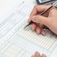 申告書類に記入する手元と電卓の写真