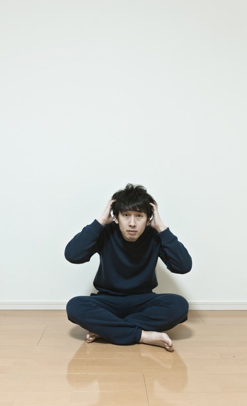 ワンルームで頭を抱える無職の男性。今後の不安と葛藤