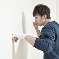 包帯を巻いた右手を掲げる男性の写真