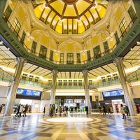 円形模様の床と黄色いガラスドームの東京駅丸の内南口ホールの写真