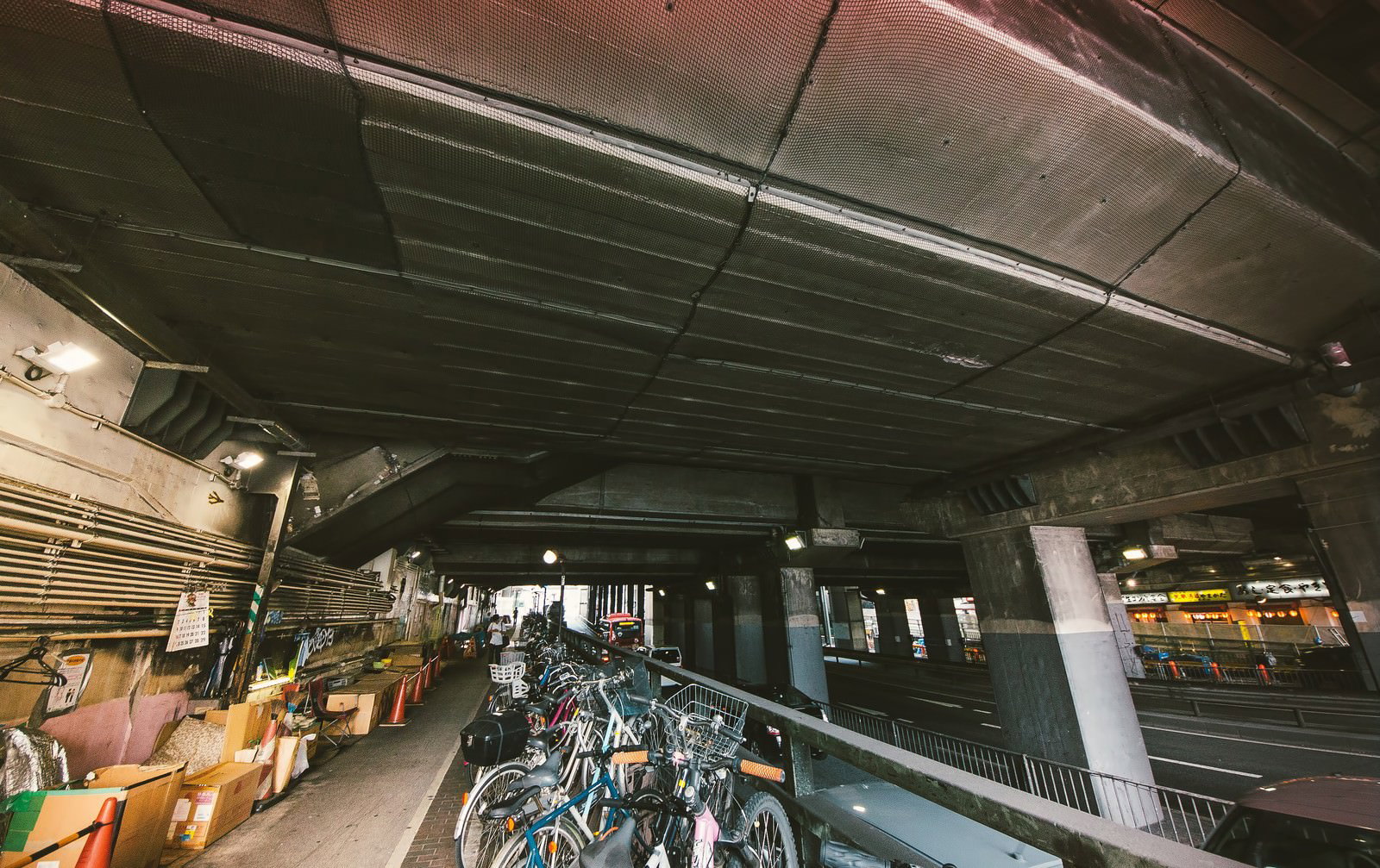 薄暗い高架下に多数の自転車が並ぶ渋谷の駐輪場