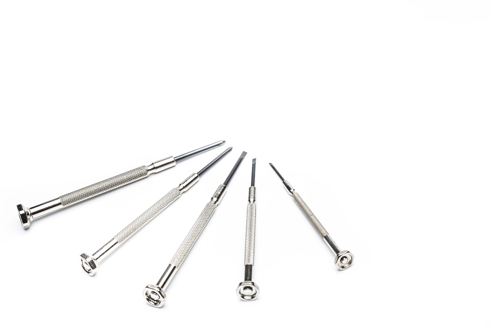 白い背景に先端の形が異なる5本の金属製精密ドライバーの扇状並び