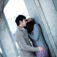 コンクリート壁の前でくっつくカップルの写真