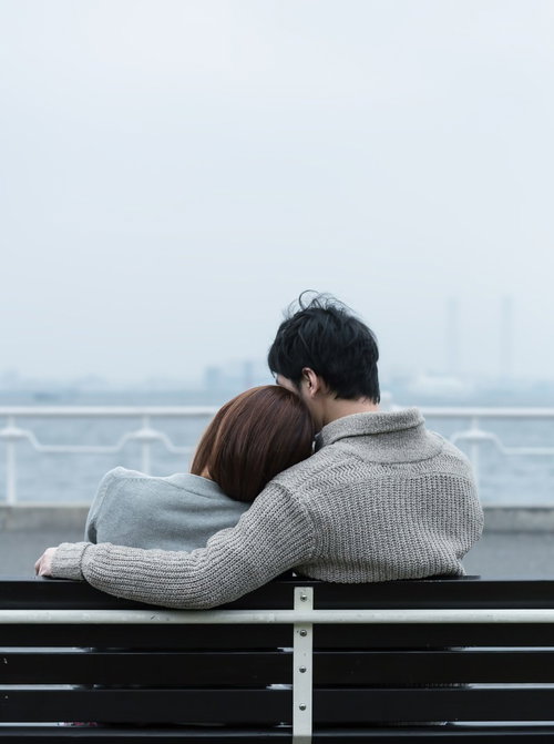 ベンチで肩を寄せ合う恋人