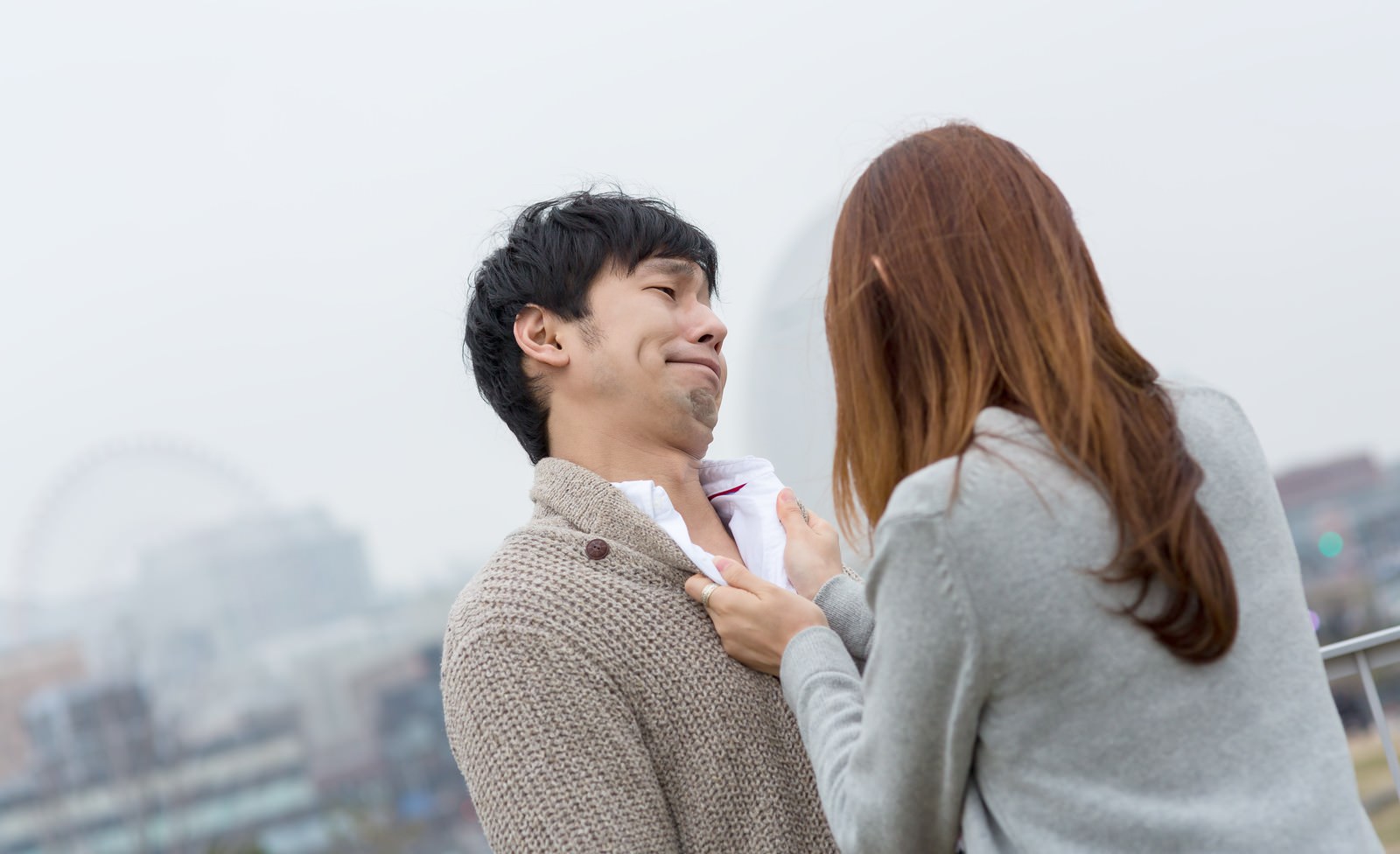 胸倉を掴まれても苦笑いする男性［モデル：大川竜弥］