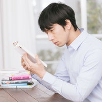 ルビがないと読めない難しい本を前に悩む男性の写真