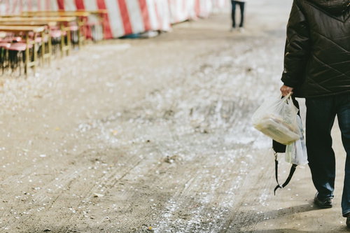 花見で買い出しに行った下っ端の男性の後ろ姿