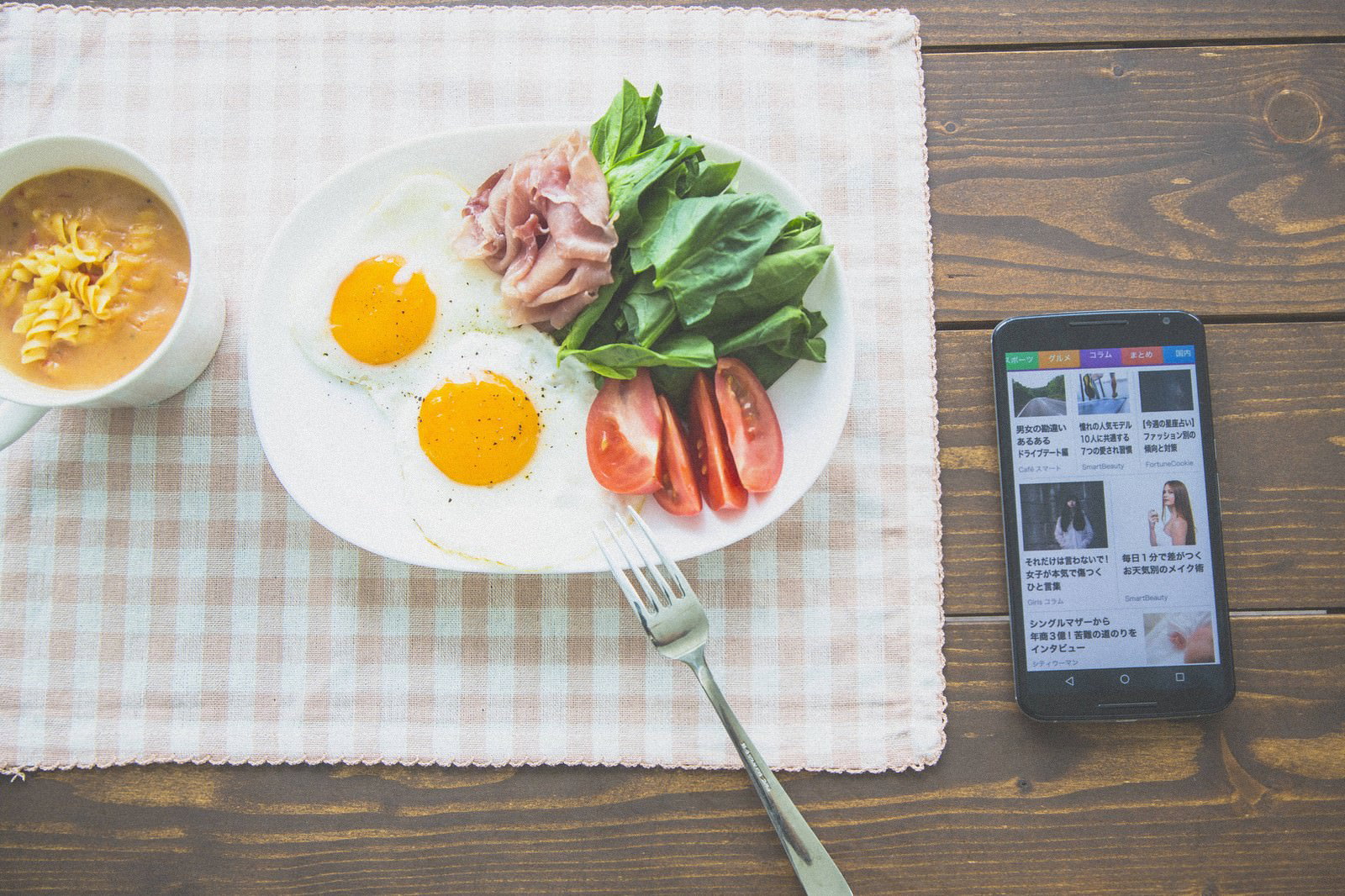 スマートニュースアプリを見ながら朝食を食べる人の上から見た光景