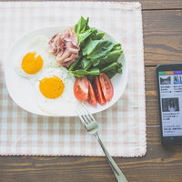 スマートニュースを見ながら朝食を食べる男性の写真