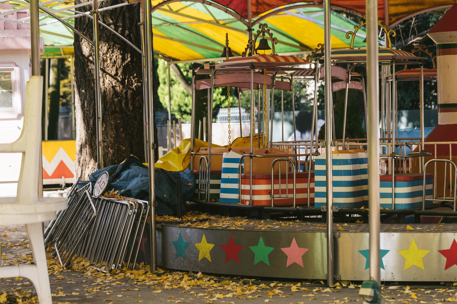 落ち葉が広がる閉園した遊園地のメリーゴーラウンド