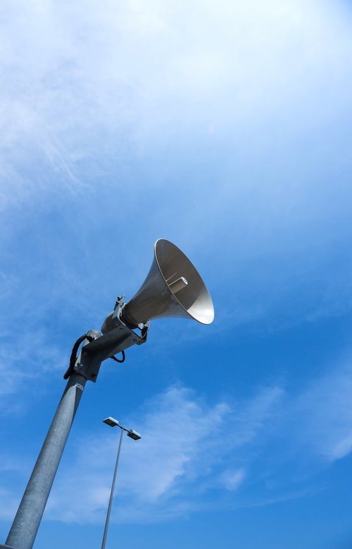 青空を背景に屋外設置のスピーカーのローアングル