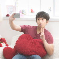 好きな女の子に送るためのセルフィを自宅でスマホ撮影している男性の写真